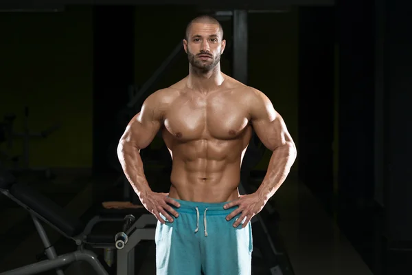 Hombre en el gimnasio mostrando su cuerpo bien entrenado —  Fotos de Stock