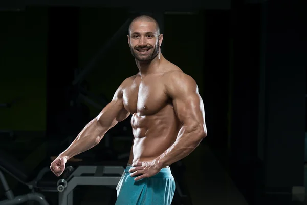 Homem no ginásio mostrando seu corpo bem treinado — Fotografia de Stock