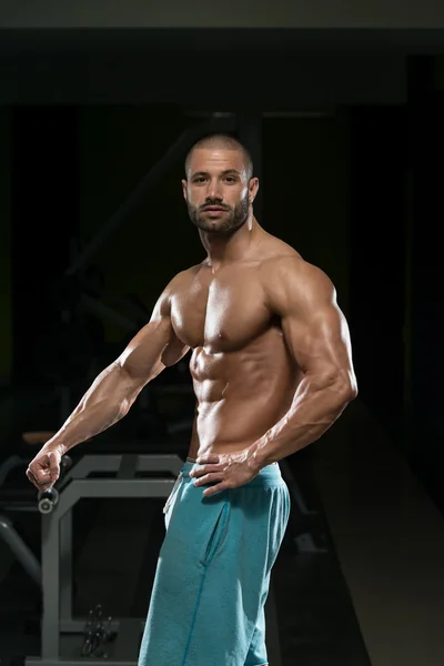 Hombre en el gimnasio mostrando su cuerpo bien entrenado —  Fotos de Stock