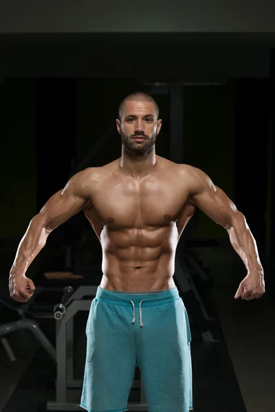 Hombre en el gimnasio mostrando su cuerpo bien entrenado — Foto de Stock