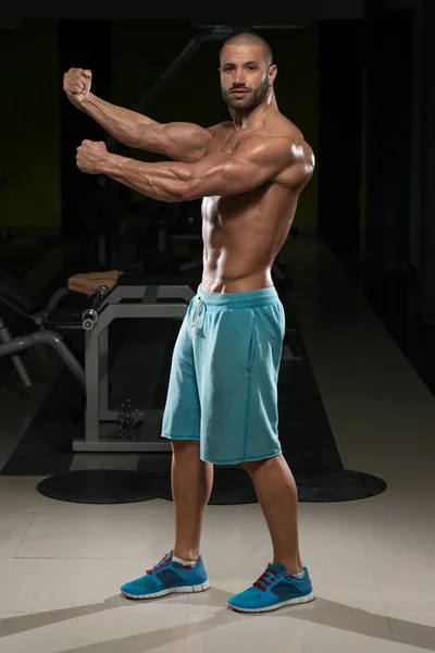 Человек в спортзале показывает свое хорошо подготовленное тело — стоковое фото