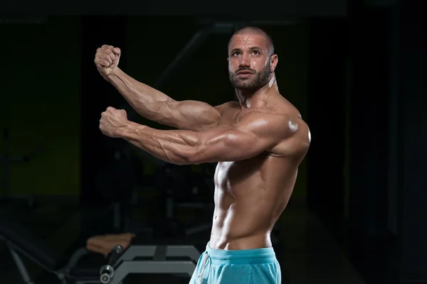 Joven hombre flexión músculos — Foto de Stock