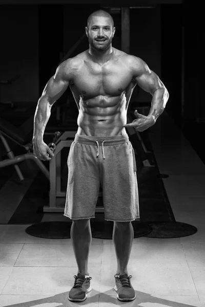 Homem no ginásio mostrando seu corpo bem treinado — Fotografia de Stock