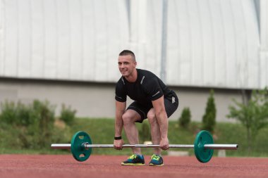Healthy Young Man Doing Exercise For Back Outdoor