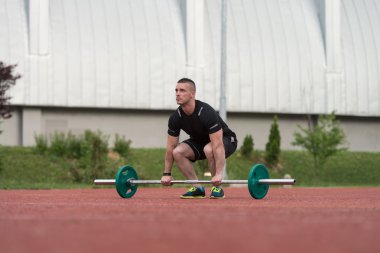Healthy Young Man Doing Exercise For Back Outdoor