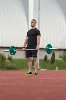 Healthy Young Man Doing Exercise For Back Outdoor