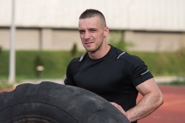 Young Man Turning Tires Outdoor