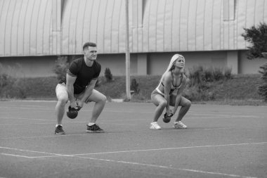 Young People Doing Kettle Bell Exercise Outdoor