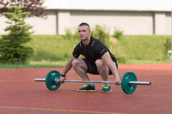 Junger Mann bei einer Kniebeuge im Freien — Stockfoto