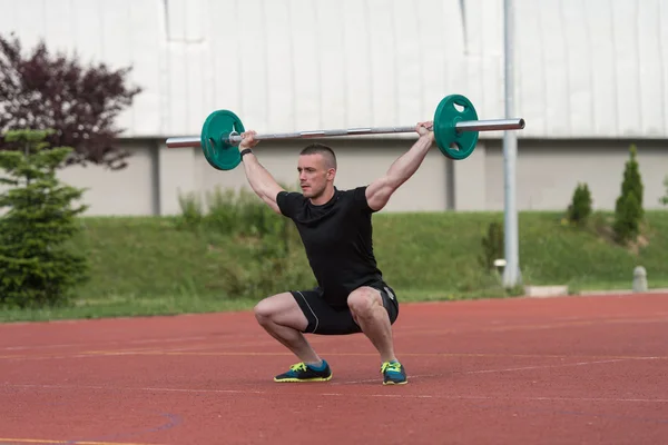 Jeune homme faisant un exercice de squat en plein air — Photo