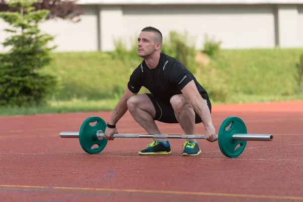 Giovane uomo facendo un esercizio squat sopraelevato all'aperto — Foto Stock