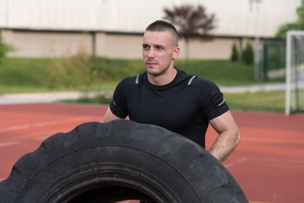 Young Man Doing Tire Flip Workout Outdoor — Stockfoto