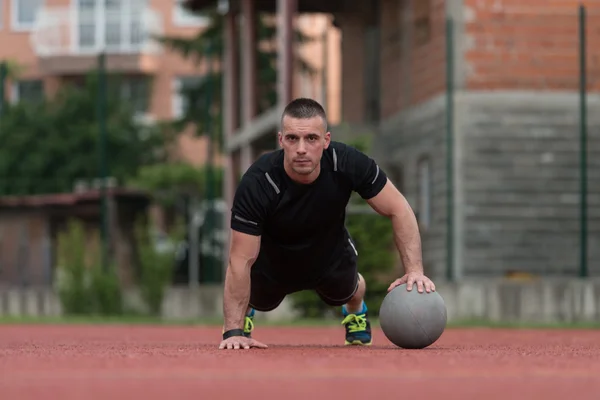 Young Man Exercising Push-Ups On Medicine Ball Outdoor — 图库照片
