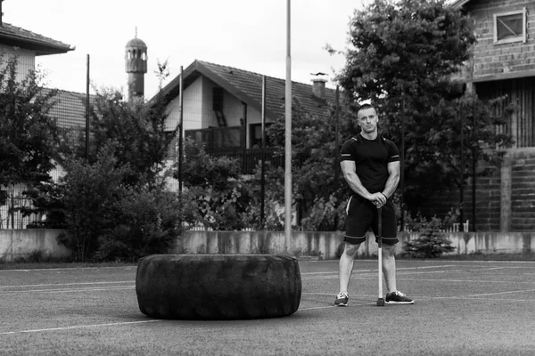 Young Man With Hammer And Tire Resting — Stok fotoğraf