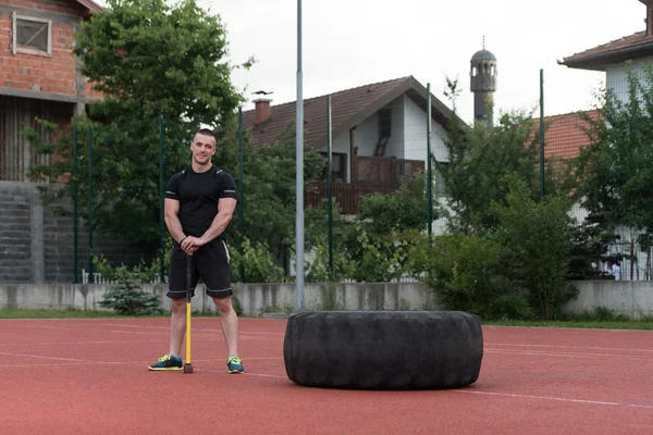 Young Man With Hammer And Tire Resting — Stok fotoğraf