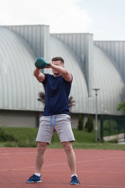 Спортивный человек тренировки с чайником Белл на открытом воздухе — стоковое фото