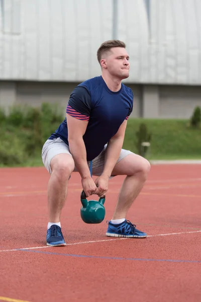 Young Man Doing Kettle Bell Exercise Outdoor — Stock fotografie