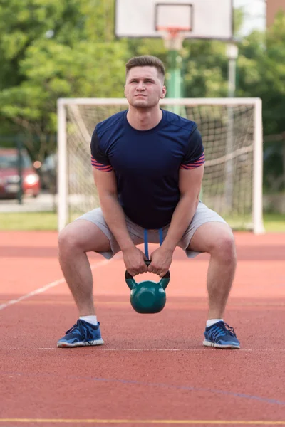 Young Man Working Out With A Kettle Bell — Zdjęcie stockowe