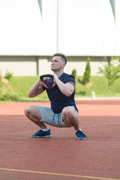 Young Man Working Out With A Kettle Bell — Stock fotografie