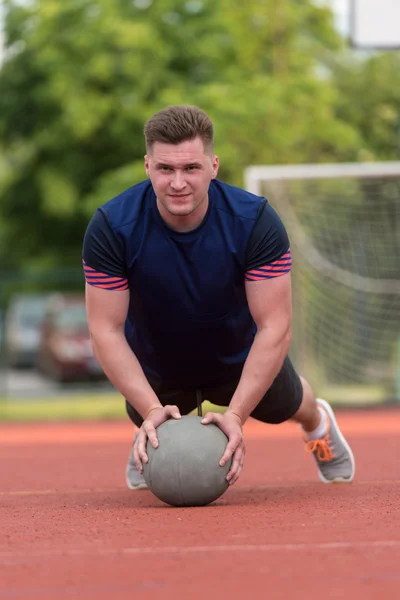 Young Man Exercising Push-Ups On Medicine Ball Outdoor — Zdjęcie stockowe