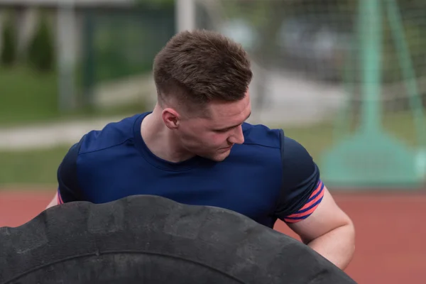 Young Man Doing Tire Flip Workout Outdoor — Stock fotografie