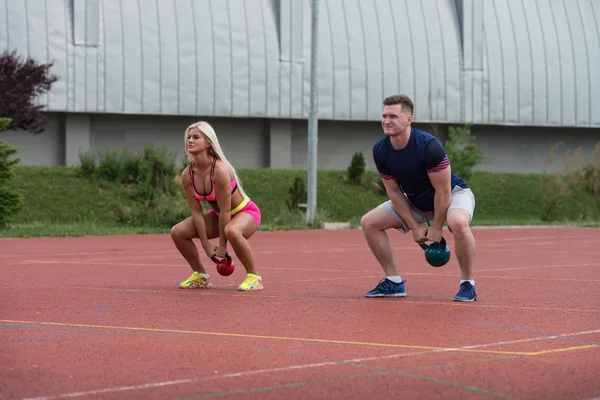 Young People Doing Kettle Bell Exercise Outdoor — Zdjęcie stockowe