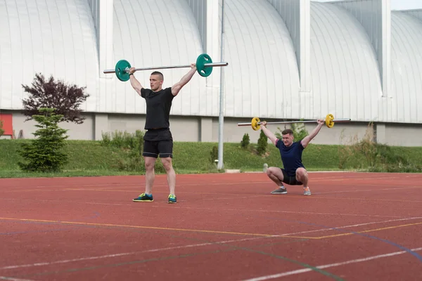 Les jeunes font un exercice de squat en plein air — Photo