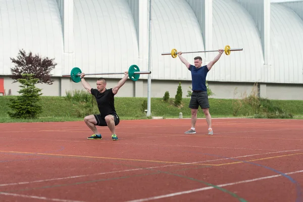 Les jeunes font un exercice de squat en plein air — Photo