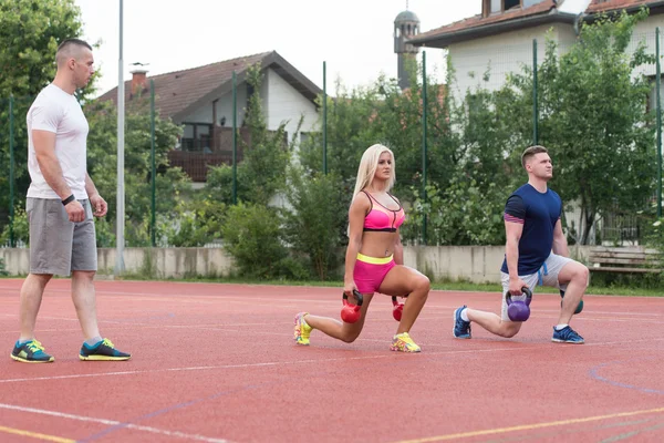 Two People Doing Kettlebell Exercise Outdoor With Instructor — Φωτογραφία Αρχείου