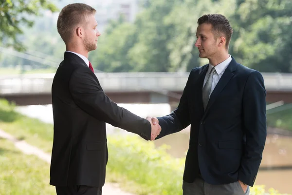 Två affärsman skakar hand hälsar varandra — Stockfoto