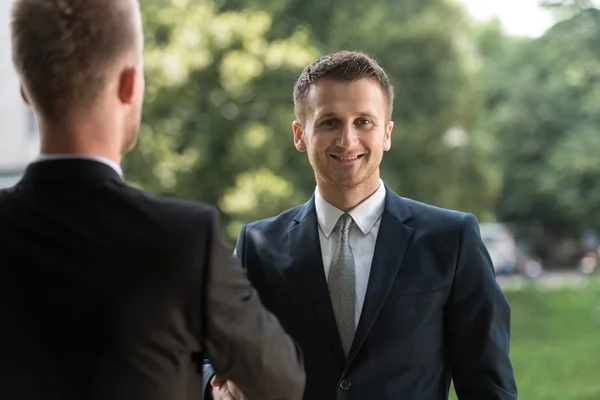 Två affärsmän skakar hand utomhus — Stockfoto