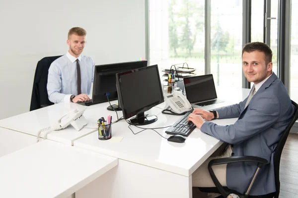 Zwei Geschäftsleute in einem Büro lächeln — Stockfoto