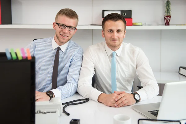 Dos hombres de negocios en una oficina sonriendo — Foto de Stock