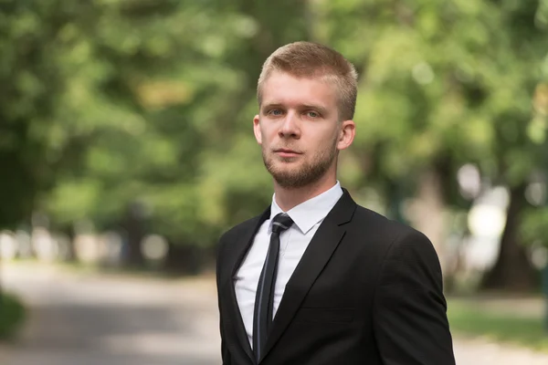 Retrato de un hombre de negocios seguro afuera en el parque — Foto de Stock