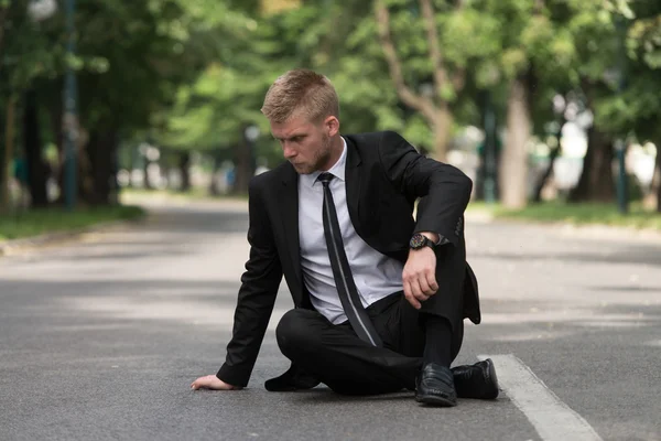 Moe zakenman zittend op asfalt buitenshuis In Park — Stockfoto