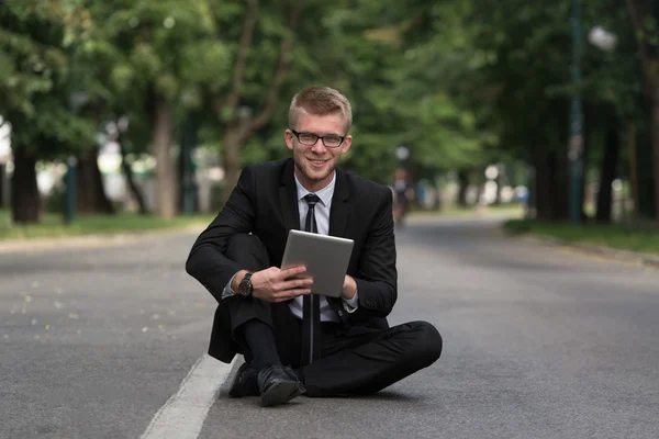 Empresário trabalhando em tablet fora do escritório — Fotografia de Stock