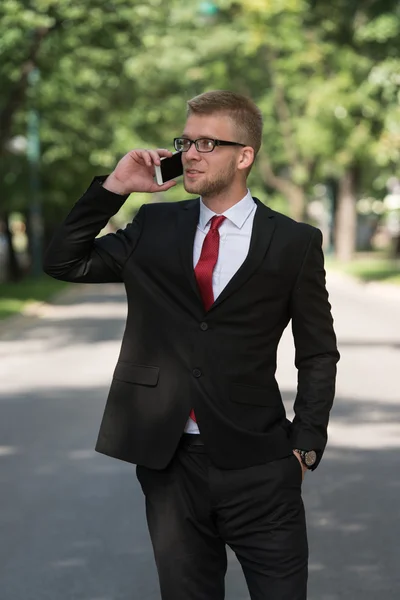 Geschäftsmann läuft im Park mit Handy draußen — Stockfoto