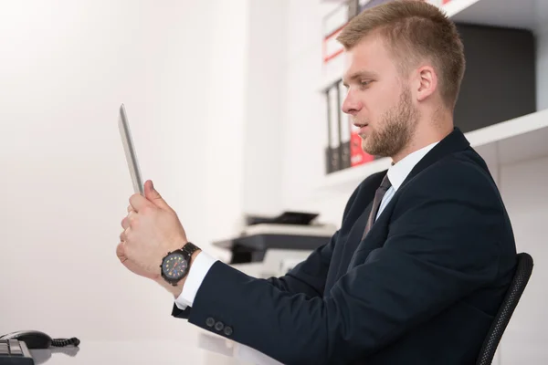 Jonge man aan het werk op touchpad in office — Stockfoto