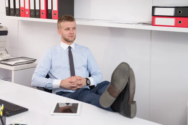 Jovem empresário relaxa sentado no escritório — Fotografia de Stock