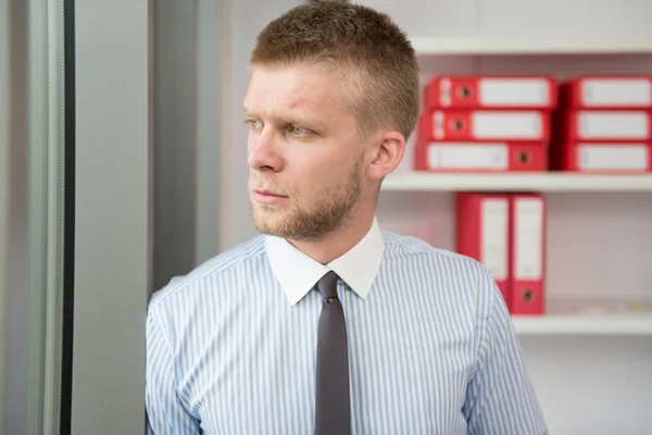 Knappe jonge zakenman portret in zijn kantoor — Stockfoto