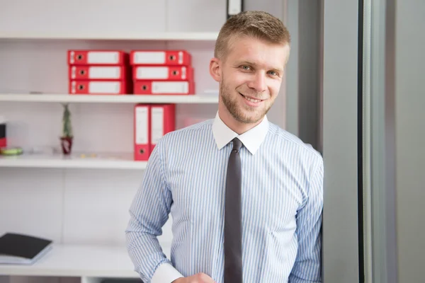 Knappe jonge zakenman portret in zijn kantoor — Stockfoto
