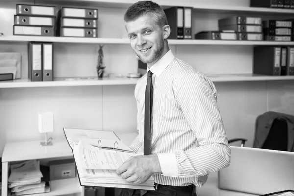 Jonge zakenman lezen van sommige kranten In Office — Stockfoto