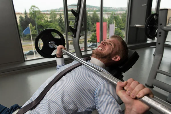 Healthy Young Businessman Doing Bench Press Exercise