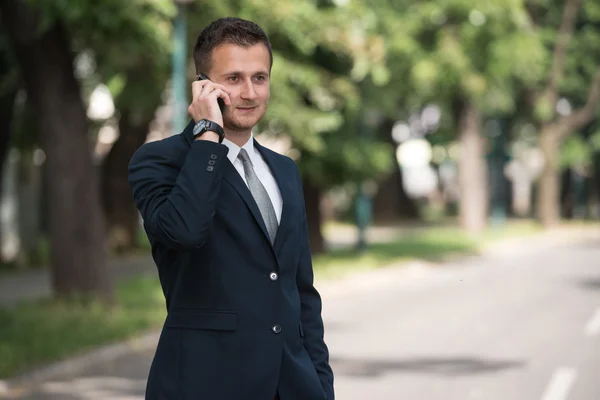 Empresario hablando por teléfono al aire libre en el parque — Foto de Stock