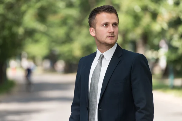 Retrato de un hombre de negocios seguro afuera en el parque — Foto de Stock