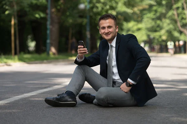 Młody biznesmen w telefonie na świeżym powietrzu w parku — Zdjęcie stockowe