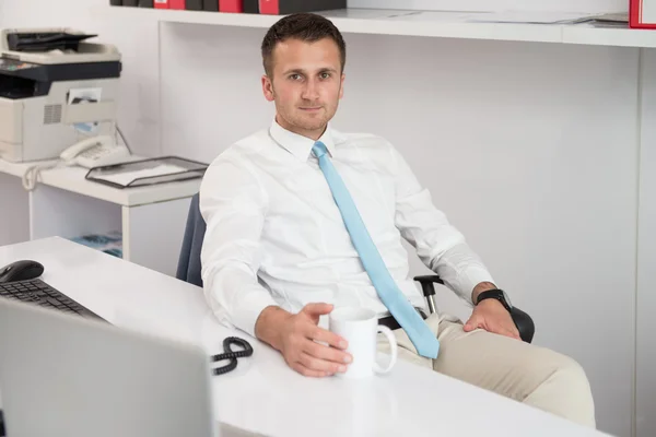 Jeune homme d'affaires se détend assis dans le bureau — Photo