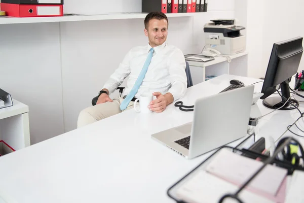 Молодой бизнесмен расслабляется, сидя в офисе — стоковое фото