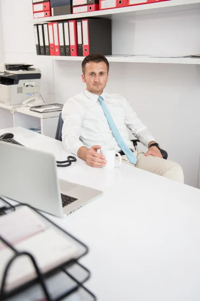 Jovem empresário relaxa sentado no escritório — Fotografia de Stock