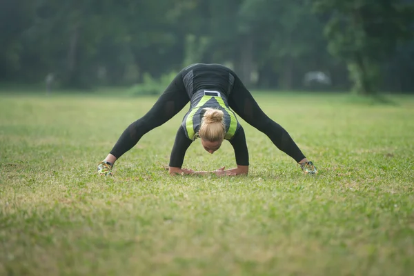 Joven chica rayando sus piernas antes de correr al aire libre — Foto de Stock